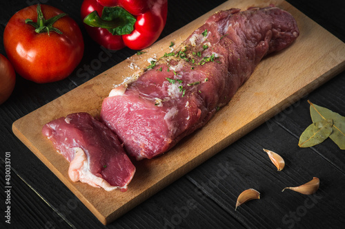 Raw beef meat with vegetables ingredients over cutting board. Preparation before preparing food in restaurant or cafe