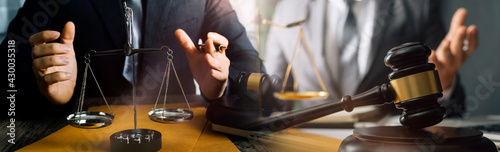 Business and lawyers discussing contract papers with brass scale on desk in office. Law  legal services  advice  justice and law concept