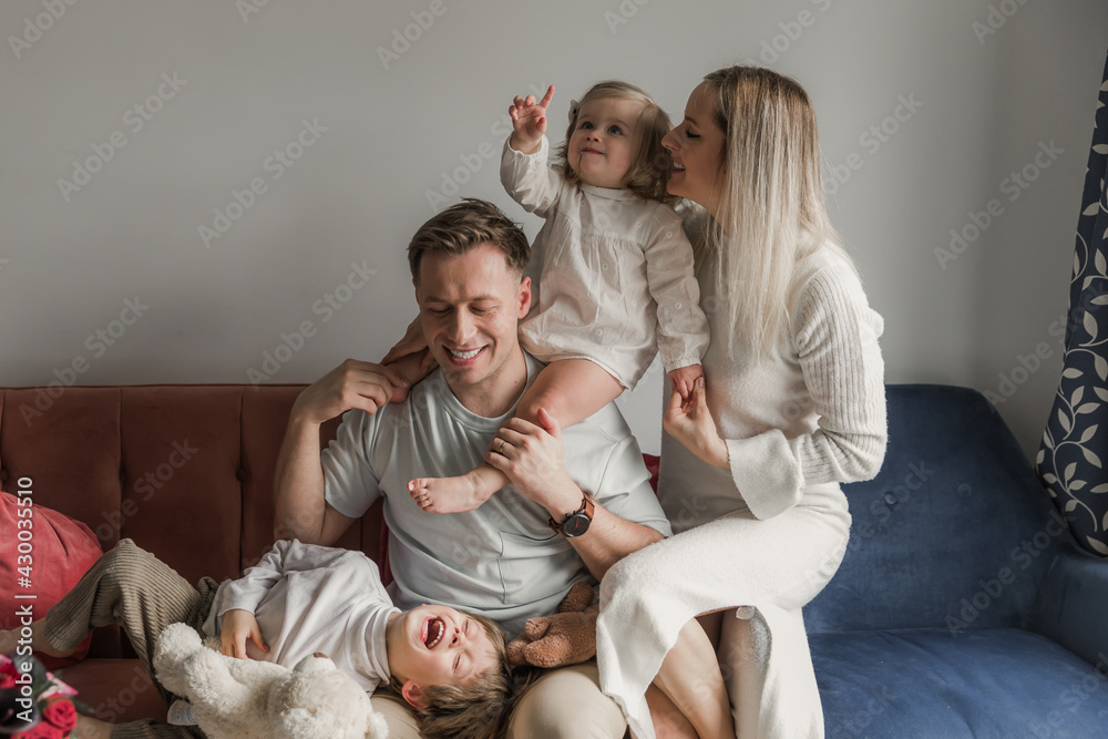 Happy young family with two children at home. Cheerfulness.