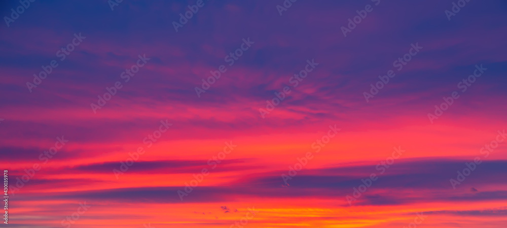 Vivid saturated beautiful sunset sky in orange, purple and red colors. Sunset background