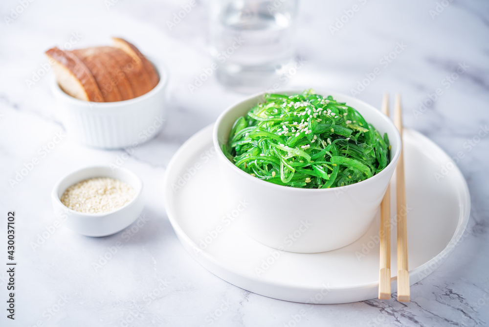 Green seaweed spicy salad with sesame seeds in a bowl Green seaweed spicy salad with sesame seeds in a bowl