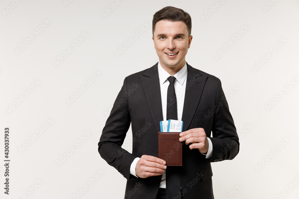 Traveler tourist business man in classic formal black grey suit hold passport tickets isolated on white office background. Passenger traveling abroad on weekends getaway. Air flight journey concept. Traveler tourist business man in classic formal black grey suit hold passport tickets isolated on white office background. Passenger traveling abroad on weekends getaway. Air flight journey concept.