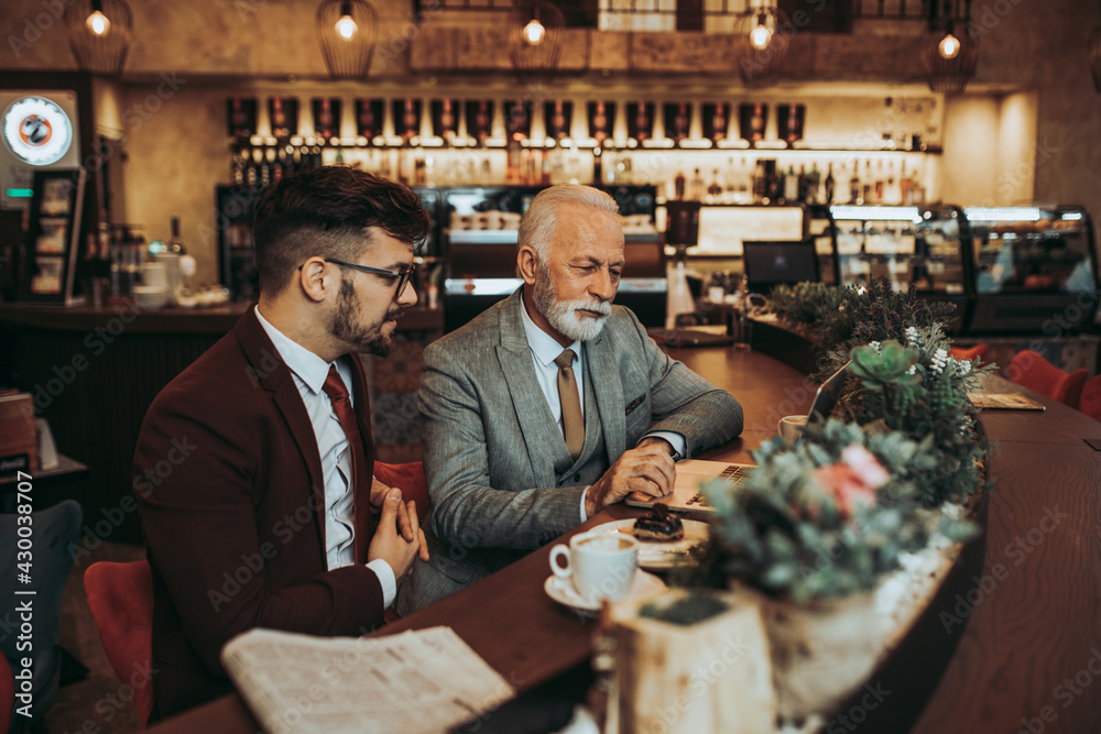  Two businessmen working together in modern cafe.