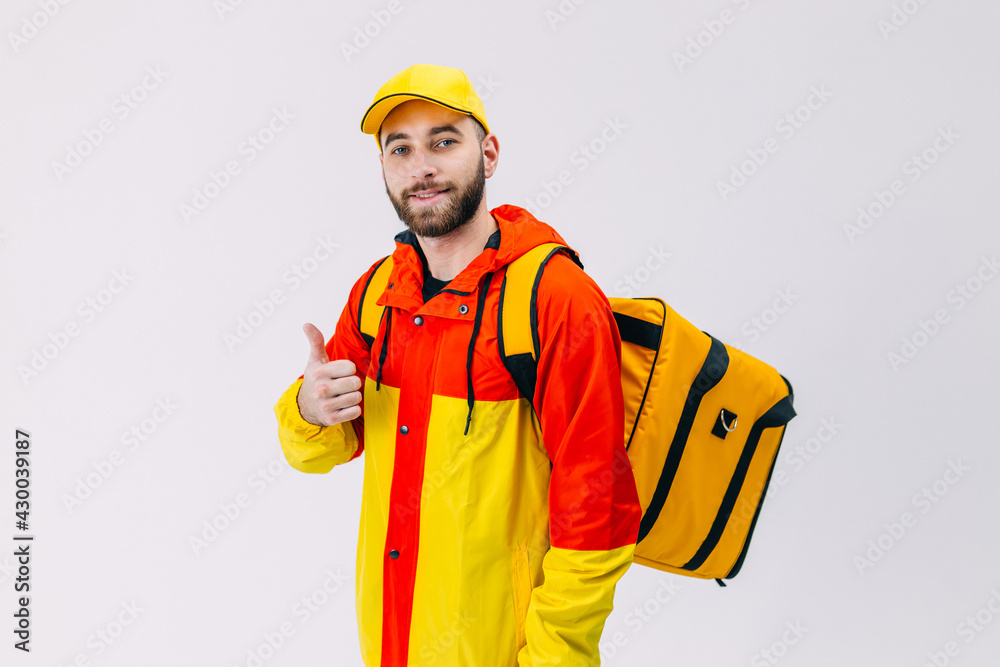 Smiling courier with thermal backpack smiles at the camera and s