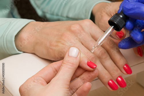 Salon care after manicure  apply a cosmetic product to the nails and skin of the fingers with a pipette