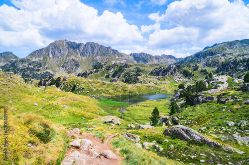 Mountainous landscape with beautiful green mountains and a lake on a sunny day. Concept of mountain trip and summer vacations. Circo Saboredo, Aran Valley-Pyrenees, Catalonia, Spain.