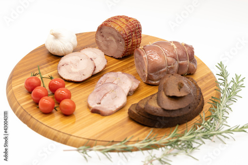 Smoked and baked Turkey roll with herbs on a wooden background.