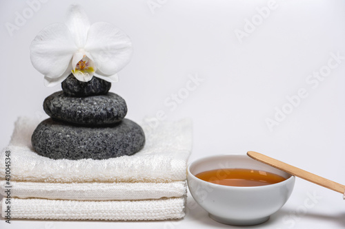 spa style  white towels  honey cup  Zen stones  orchid  everything for a relaxing massage