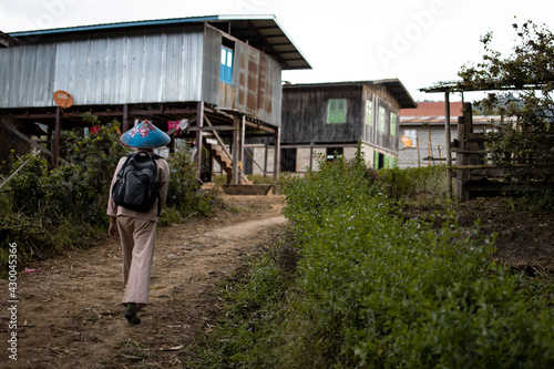 Burmese man in traditional clothing trek into a local village