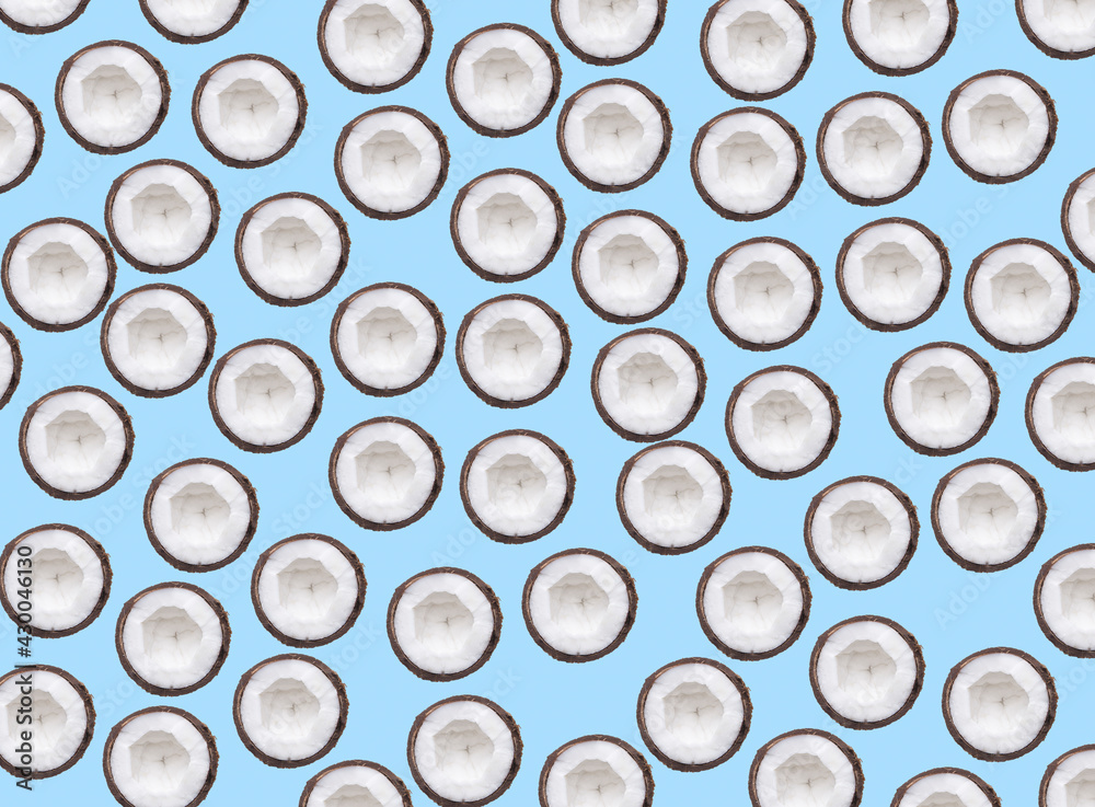 Multiplied sliced coconut half on pastel blue background. Tropical fruits. Summer concept. Multiplied sliced coconut half on pastel blue background. Tropical fruits. Summer concept.