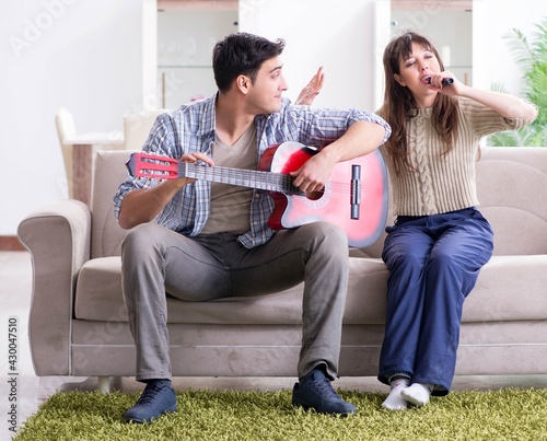 Young family singing and playing music at home