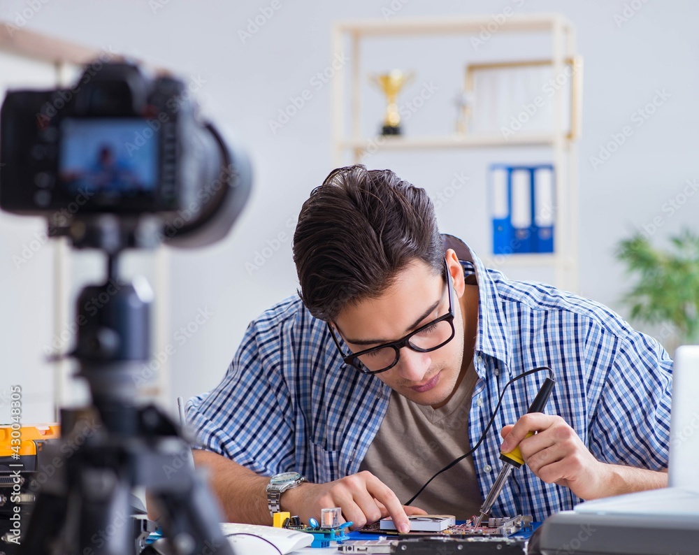 Vlogger recording computer repair on camera for vlog blog