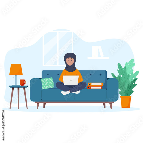 Muslim woman works at a laptop. Freelance concept.