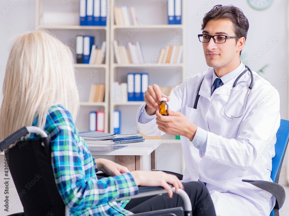 Obraz premium Disabled woman in wheel chair visiting man doctor