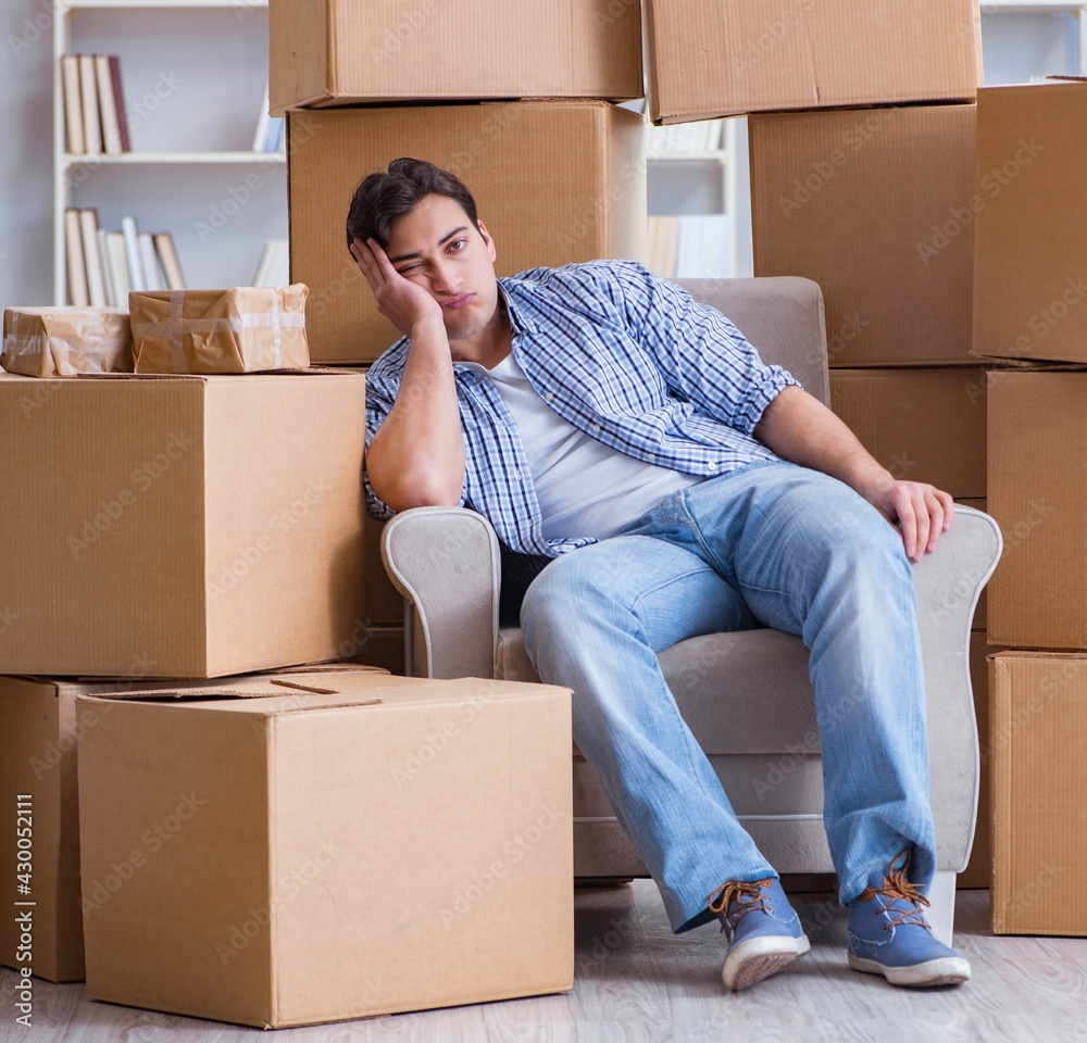 Young man moving in to new house with boxes Young man moving in to new house with boxes