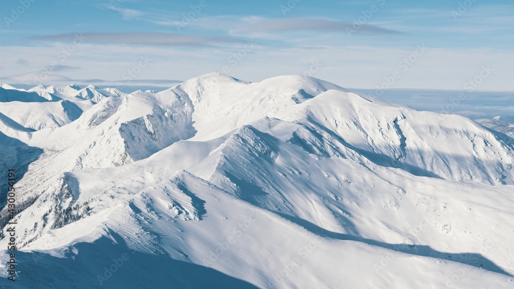 Snowy Mountains In The Winter Landscape With Cloudy Blue Sky During The Day Time. High quality photo Snowy Mountains In The Winter Landscape With Cloudy Blue Sky During The Day Time. High quality photo