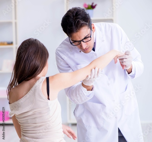 Doctor examining the skin of female patient