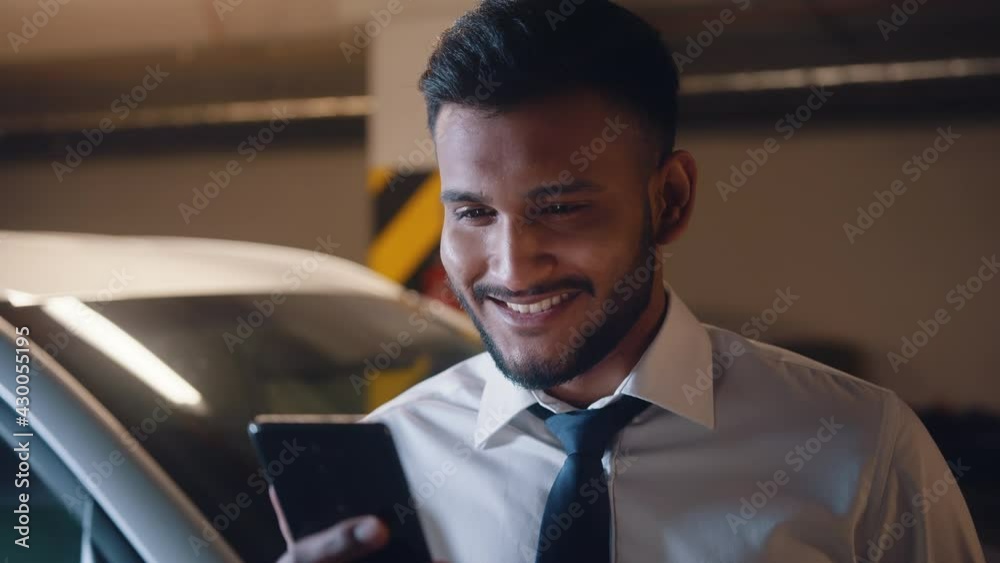 Smiling businessman making video call in underground garage. High quality 4k footage Smiling businessman making video call in underground garage. High quality 4k footage