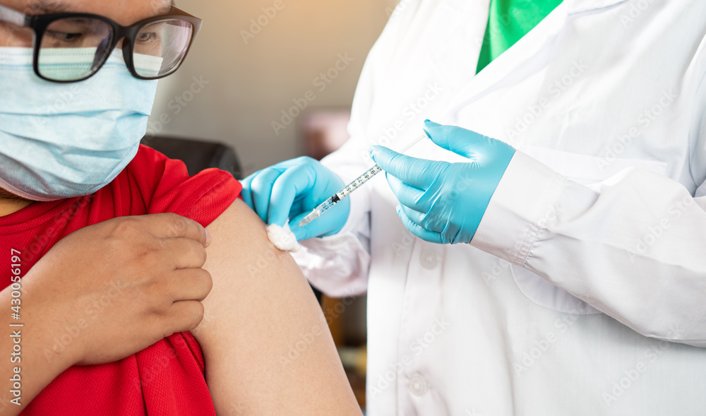 Doctor holding syringe and using cotton before make injection to patient in medical mask. Covid-19 or coronavirus vaccine concept. Vaccine protect coronavirus outbreak. Doctor holding syringe and using cotton before make injection to patient in medical mask. Covid-19 or coronavirus vaccine concept. Vaccine protect coronavirus outbreak.