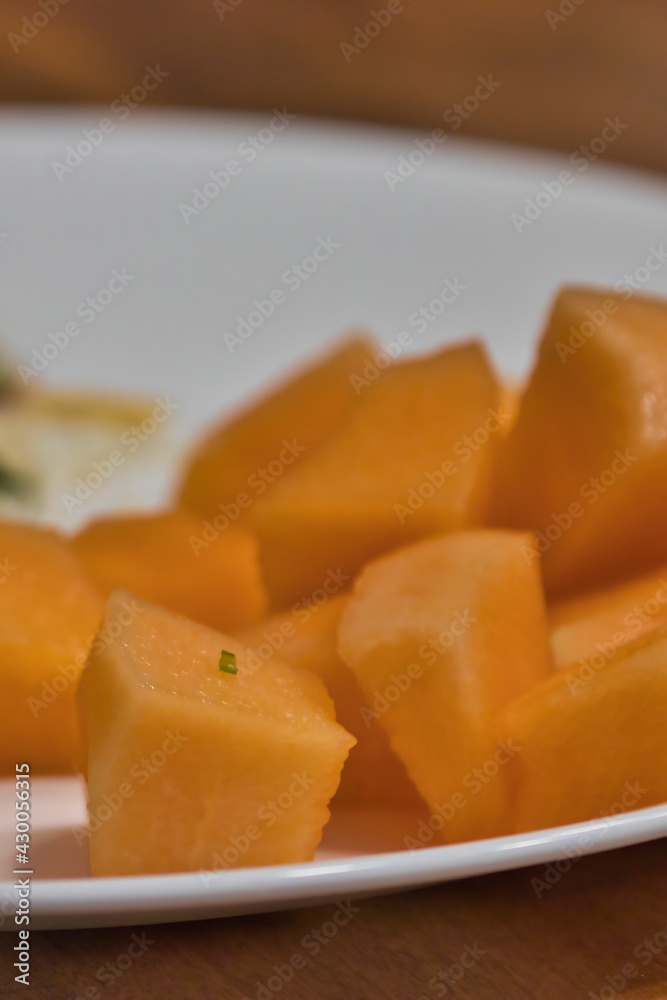 a side of cantaloupe served on a white plate a side of cantaloupe served on a white plate