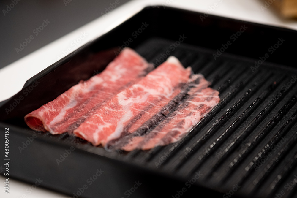 Thin sliced beef for Shabu hot pot on black tray