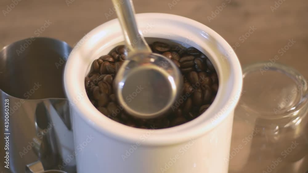 Stirring and Scooping up fresh roasted Coffee Beans from India Stirring and Scooping up fresh roasted Coffee Beans from India