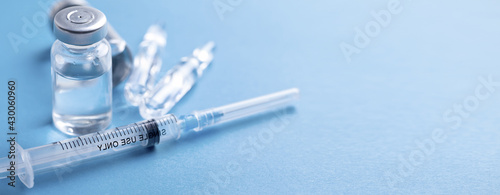 Medical syringe with a needle and a bollte with vaccine.