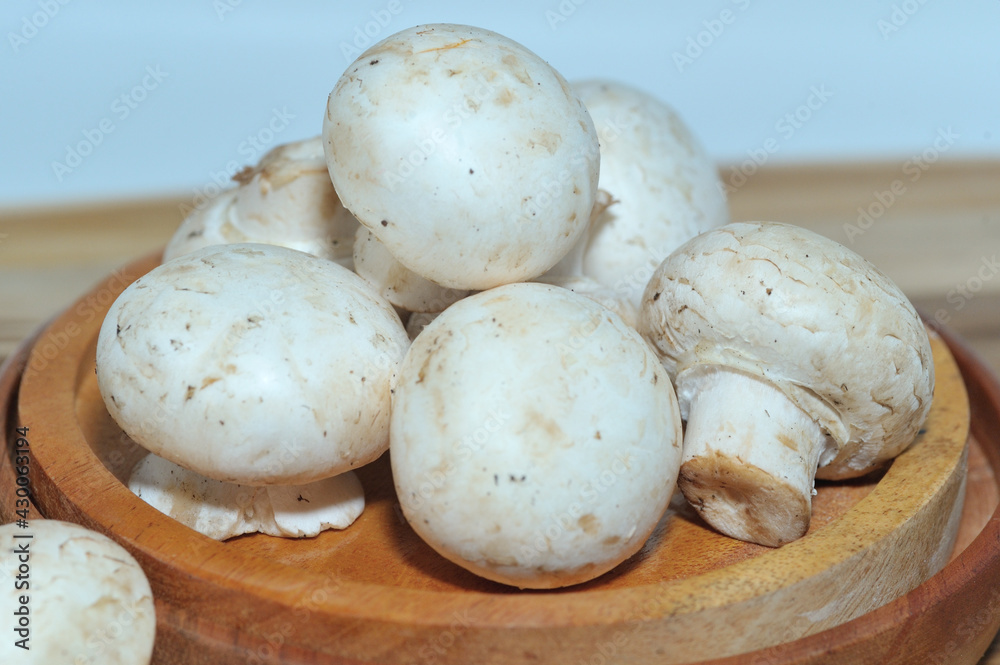 Mushrooms on a wooden chopping board on a white background