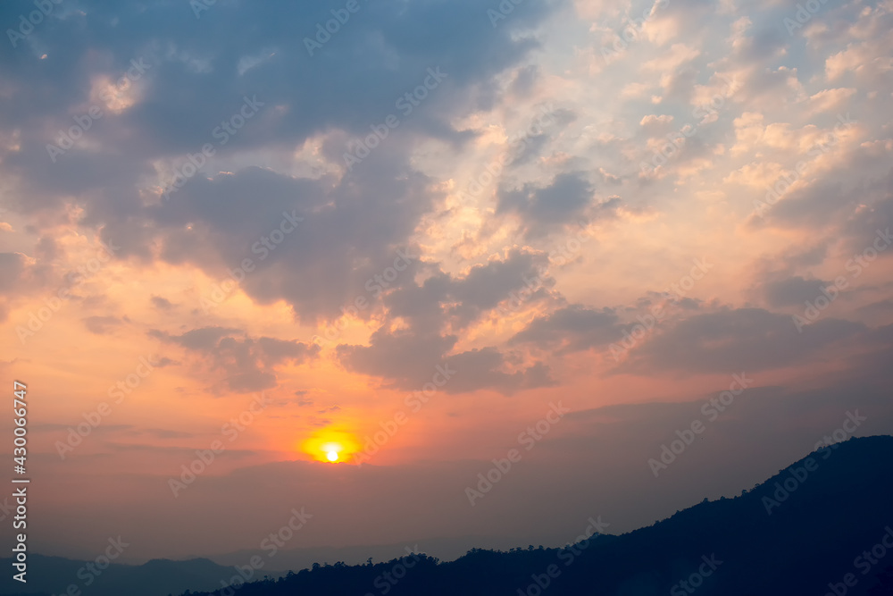 The landscape in the sky at sunset, orange light shines on the beautiful clouds on the mountain top. Gives you a feeling of loneliness but beautiful