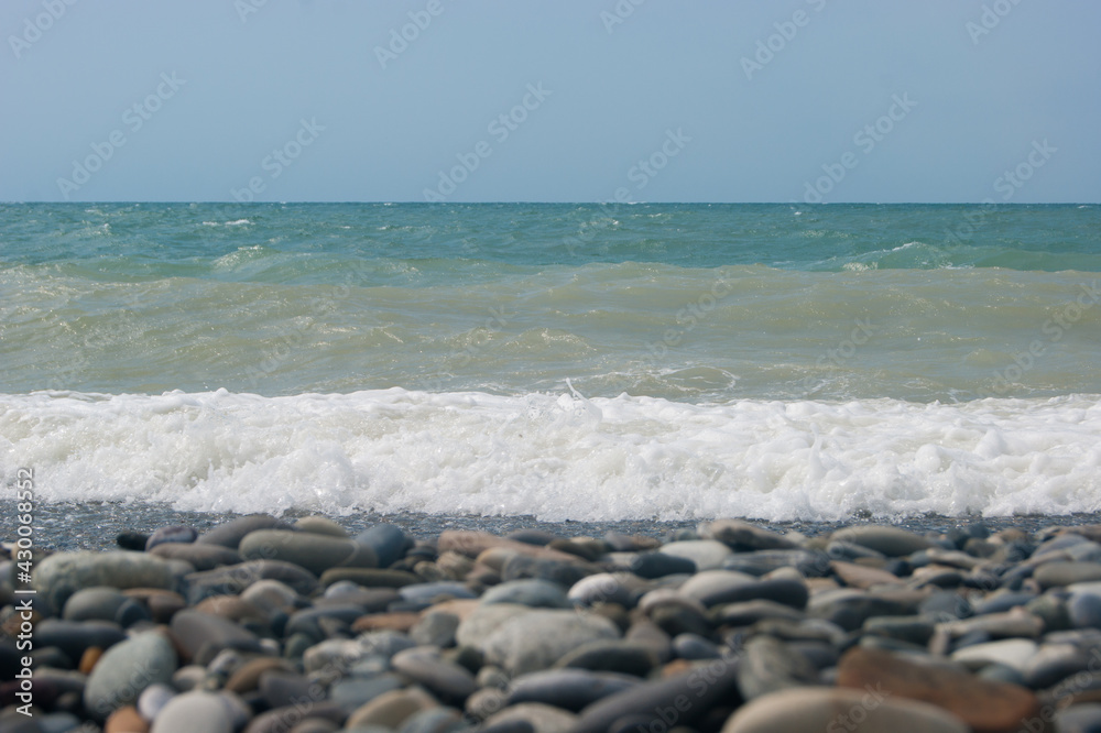 The Sea Wave of the Black Sea is a pebble beach. Smooth horizon, blue sky. The Sea Wave of the Black Sea is a pebble beach. Smooth horizon, blue sky.