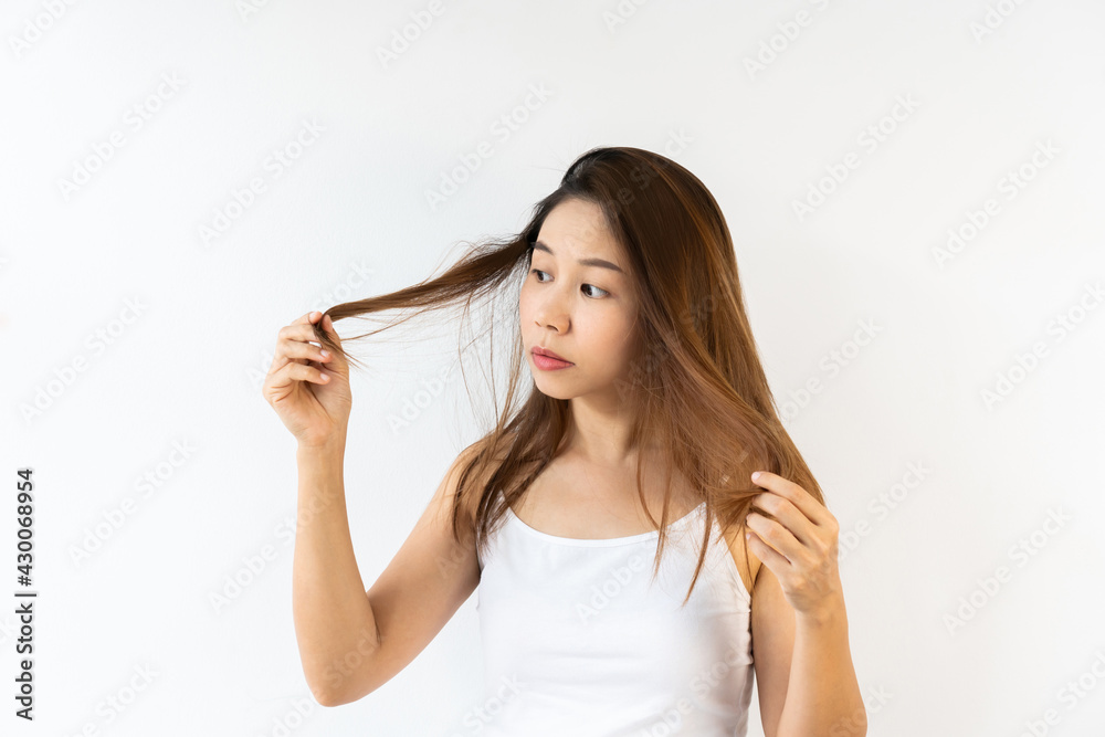 Portrait of frustrated young Asian brunette woman with messed hair on white background. Close up. Portrait of frustrated young Asian brunette woman with messed hair on white background. Close up.