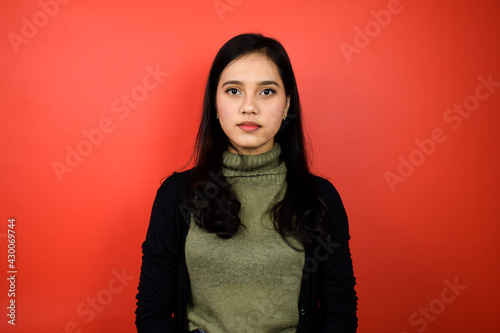 Smiling and look at camera of Young beautiful asian women using black sweater with red isolated background