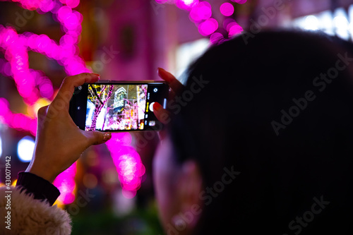 Photography A Japanese girl shooting illumination at the night street in Shibuya close shot