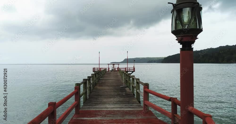Aerial view over a pier at the Bom Bom beach, in cloudy Principe - low, drone shot Aerial view over a pier at the Bom Bom beach, in cloudy Principe - low, drone shot