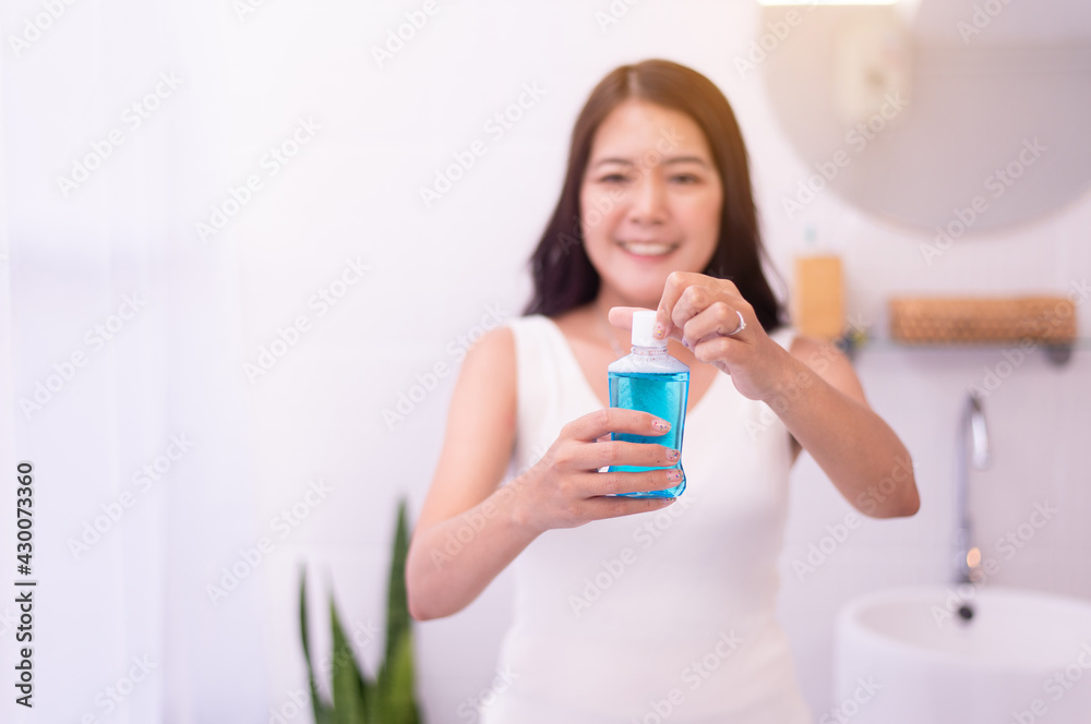 Woman using mouthwash to rinsing mouth in restroom,Fresh breath,Dental health care concept Woman using mouthwash to rinsing mouth in restroom,Fresh breath,Dental health care concept