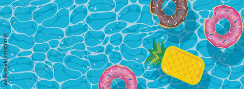 Summer background for flyers or pool party invitations. Pool party. Azure water with donut and pineapple inflatable rings.