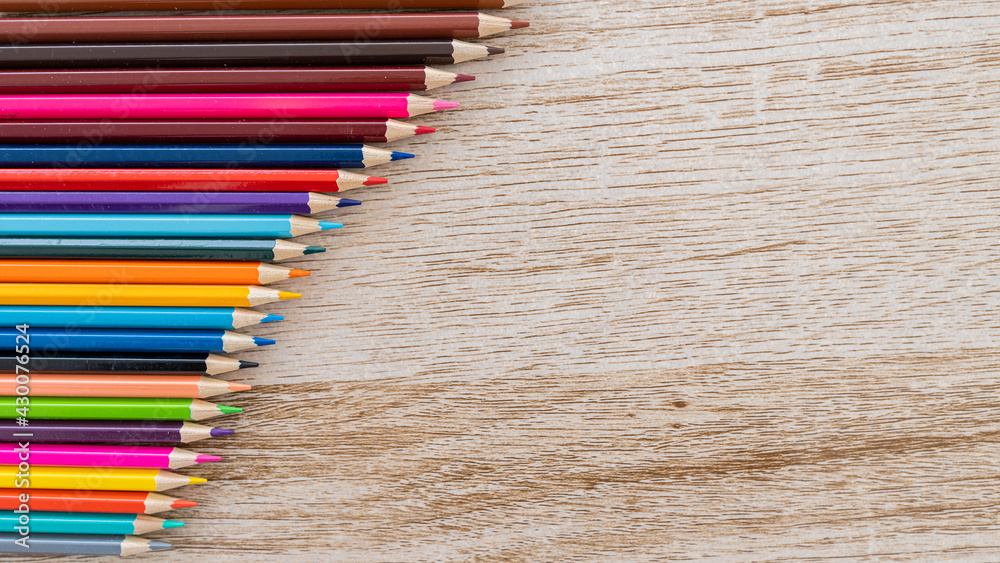 Obraz premium Colorful colored pencils arranged on a wooden table