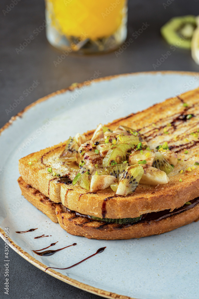 Kiwi, banana and chocolate toast with fresh orange juice. Kiwi, banana and chocolate toast with fresh orange juice.
