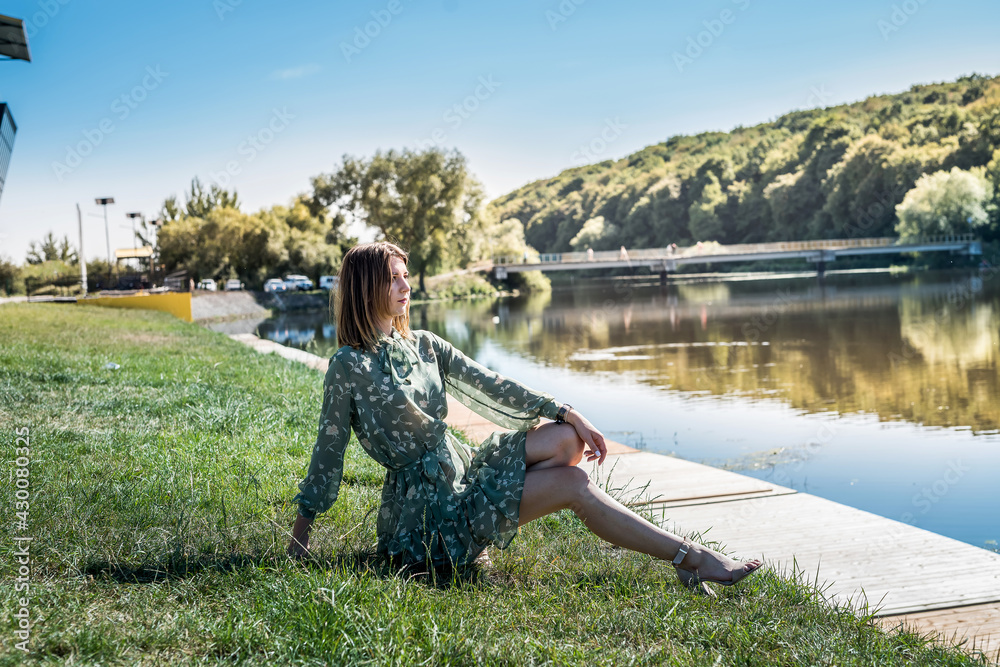 elegant woman in fashion dress stands near a blue lake in sunny summer day elegant woman in fashion dress stands near a blue lake in sunny summer day