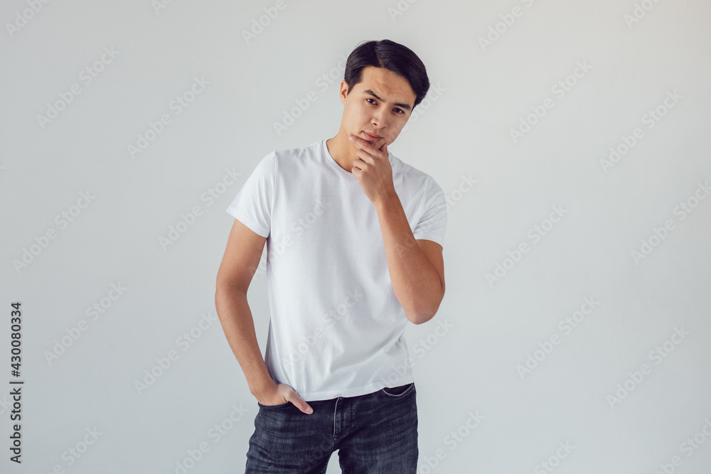 Attractive asian man in white t-shirt stands on white background. Attractive asian man in white t-shirt stands on white background.