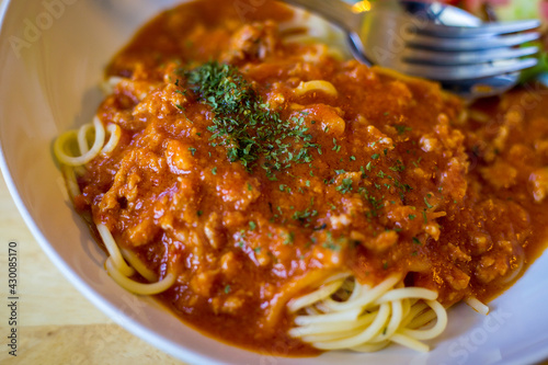 Spaghetti with minced beef tomato sauce and fresh basil on wooden table