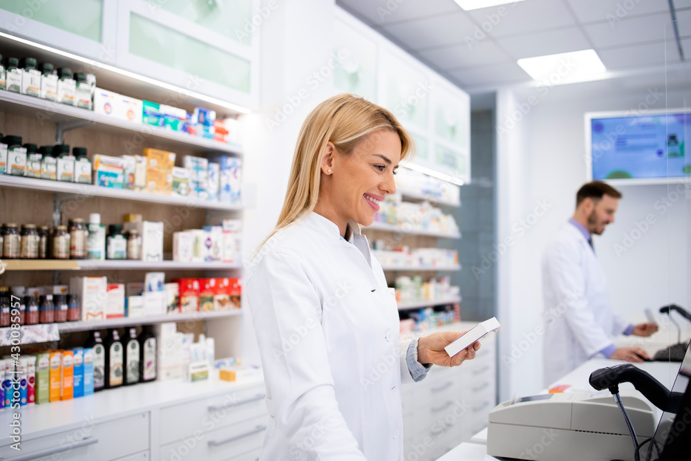 Female caucasian pharmacist selling medicines in pharmacy store. Female caucasian pharmacist selling medicines in pharmacy store.