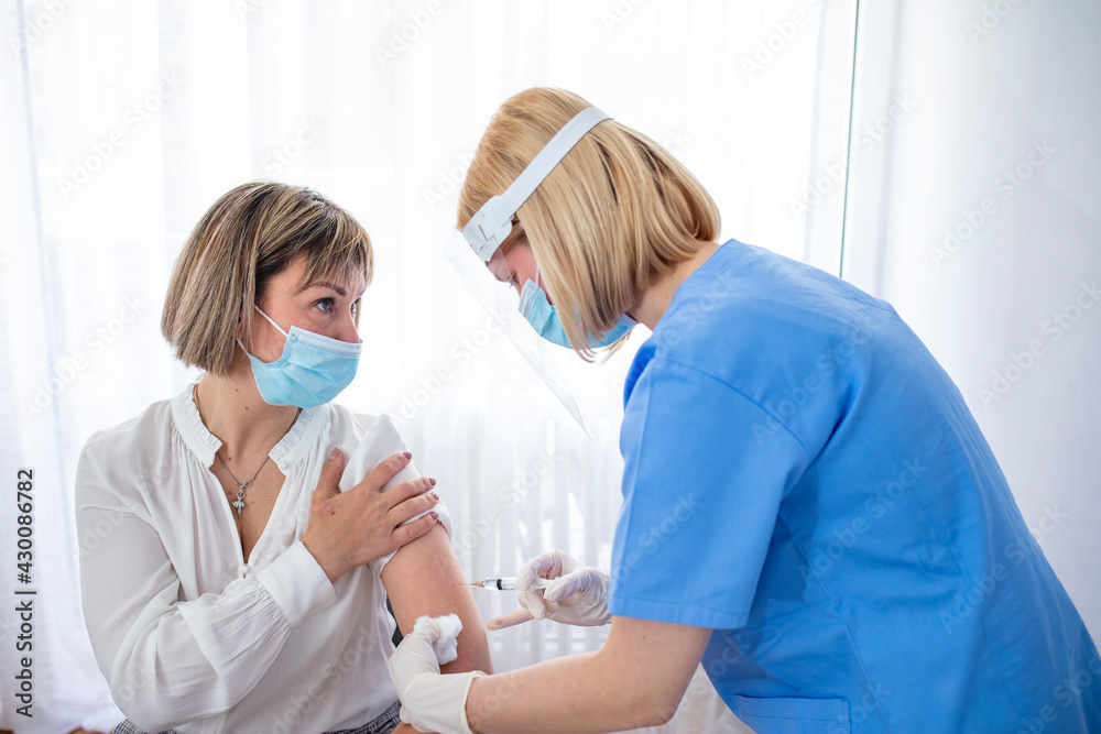Doctor's hands in surgical gloves preparing COVID-19 vaccine for female patient. Vaccination, immunization campaign, disease prevention concept. Professional nurse giving flu injection to patient Doctor's hands in surgical gloves preparing COVID-19 vaccine for female patient. Vaccination, immunization campaign, disease prevention concept. Professional nurse giving flu injection to patient