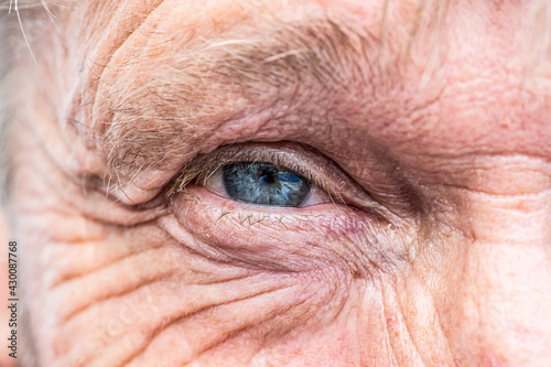 Close-up macro view on the blue eye of senior man smiling