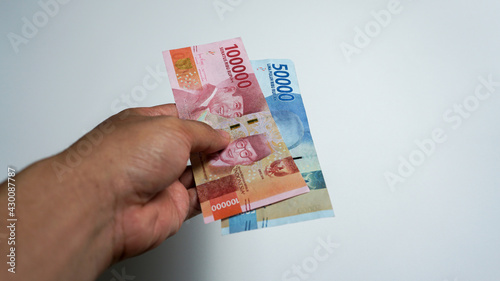 Men's hands showing Indonesian rupiah currency