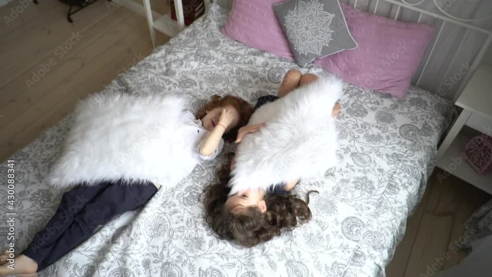 Brother and sister fight pillows on bed Brother and sister fight pillows on bed