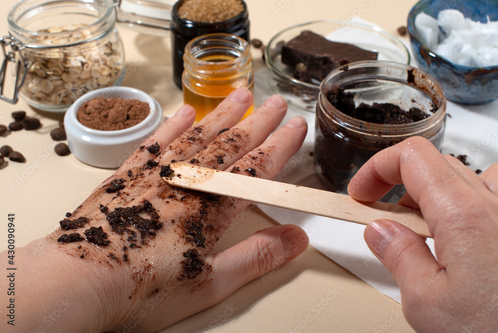 Womans hands testing chocolate face and body scrub. Womans hands testing chocolate face and body scrub.