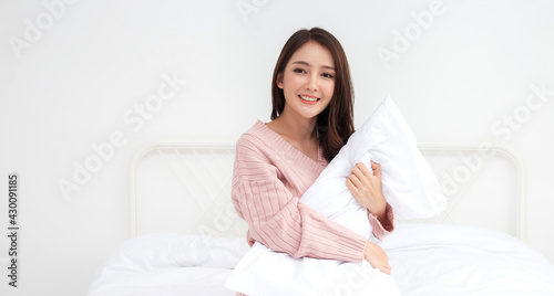 Smiling of cheerful beautiful pretty asian woman clean fresh healthy white skin posing in warm knitted pink clothes.Girl felling relaxing and enjoy time on the bed at home.asia beauty