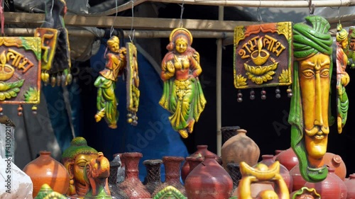 Beautiful wall hangings and other decoratives in a street market of Delhi/NCR  India. Closeup shot of a decorated roadside stall with colorful showpieces  vases  money banks(Gullaks) out for sale  photo