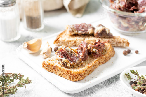 Toast with homemade beef stew on a white serving board light background closeup